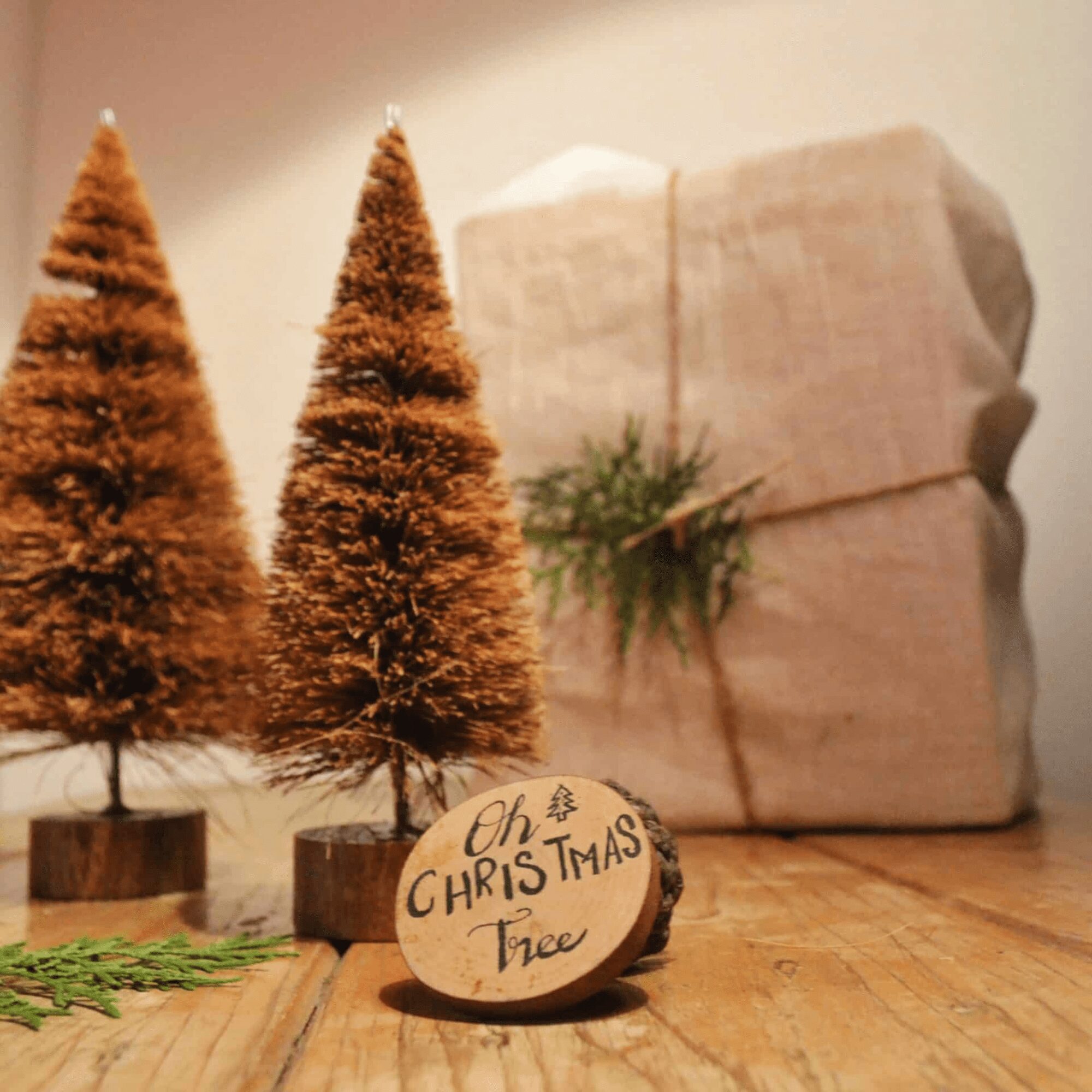 A 30 cm handcrafted Christmas tree made from natural coconut coir fiber and mounted on a rustic wooden base, surrounded by pinecones and eco-friendly holiday decor — sustainable Christmas decoration by Almitra Sustainables.